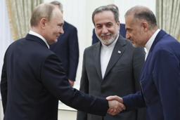 　２３日、ロシア・モスクワで会談する前のプーチン大統領（左）とイランのアラグチ外相（中央）（ＡＰ＝共同）