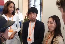 　英議会関係者と話す東条英利さん（中央）とジェニファー・テーゲさん（左）＝２４日、ロンドン（共同）
