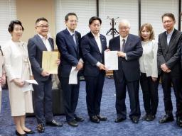 　高額療養費制度に関する超党派の国会議員連盟から、要請を受ける福岡厚労相（左から４人目）＝２５日午後、厚労省