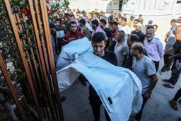 　２８日、ガザ南部ハンユニスで、イスラエル軍の攻撃により親族が殺害されて嘆く人たち（ゲッティ＝共同）