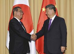 　２０２４年１１月、首脳会談を前に握手する石破首相（左）と中国の習近平国家主席＝ペルー・リマ（共同）