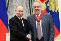 　モスクワのクレムリンで、指揮者のゲルギエフ氏（右）に勲章を授与して握手するロシアのプーチン大統領＝２０２４年５月（タス＝共同）