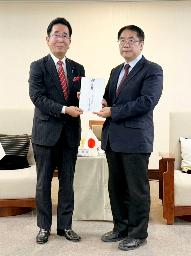 　２３日、台湾・台南市で黄偉哲市長（右）に見舞金を手渡す、日台友好促進山口県議会議員連盟の島田教明会長（野崎孝男・台湾行政院政務顧問提供、共同）