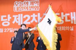 　韓国の保守系少数野党「改革新党」の代表に選出され、党旗を振る李俊錫氏＝２７日、ソウル（共同）