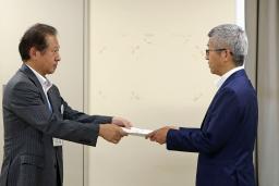 　東北電力女川原発敷地内に「乾式貯蔵施設」を設置する計画について、宮城県庁で担当者（左）から回答書を受け取る東北電原子力本部の阿部正信原子力部長＝２９日午後