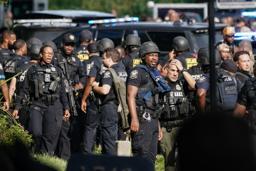 　８日、米南部アトランタにある疾病対策センター（ＣＤＣ）の施設で、銃撃事件の対応に当たる警察官ら（ゲッティ＝共同）