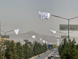 　１４日、アフガニスタンの首都カブールで、復権４年を祝って掲げられたタリバンの旗（共同）