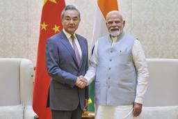 　１９日、ニューデリーで握手するインドのモディ首相（右）と中国の王毅外相（インド首相府提供・ＡＰ＝共同）