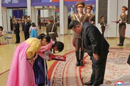 　戦死した北朝鮮兵の遺族と面会する金正恩朝鮮労働党総書記（手前右）＝２９日、平壌（朝鮮中央通信＝共同）