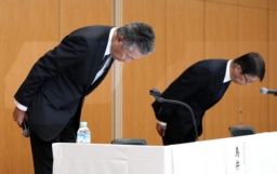 　新浪剛史会長の辞任について、記者会見で頭を下げるサントリーＨＤの鳥井信宏社長（左）と山田賢治副社長＝２日午後、東京都港区