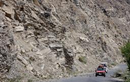 　アフガニスタン東部クナール州ヌールガルで、落石を避けて通る車＝５日（共同）