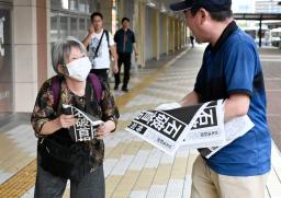 　石破首相が辞任の意向を固めたことを伝える号外を受け取る女性＝７日午後５時１９分、ＪＲ鳥取駅前