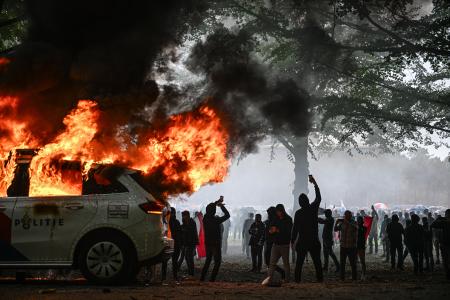 　オランダ西部ハーグで２０日、反移民デモが過激化。警察車両が燃やされた（ゲッティ＝共同）