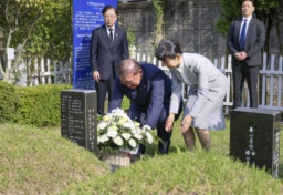　ＪＲ新大久保駅転落事故で亡くなった韓国人留学生の李秀賢さんの墓地を参拝し、献花する石破首相。右は妻の佳子さん＝３０日、韓国・釜山（内閣広報室提供・共同）