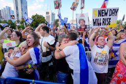 　パレスチナ自治区ガザでイスラム組織ハマスが拘束していた人質の引き渡しが始まったと報じられ、喜ぶ人たち＝１３日、イスラエル中部テルアビブ（共同）