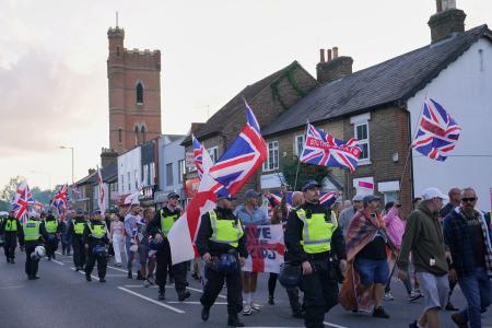 難民申請者のホテル滞在政策に反対する人たち=8月31日、ロンドン(AP=共同)
