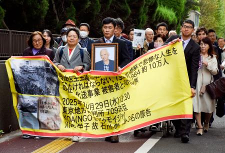 差し戻し審第1回口頭弁論のため、東京地裁に入る原告側=29日午後