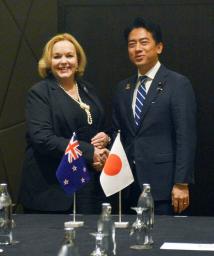 　ニュージーランドのコリンズ国防相（左）と握手する小泉防衛相＝２日、クアラルンプール（共同）