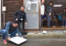 　衛星インターネットサービス「スターリンク」を設置する住民ら＝２日午前、石川県かほく市