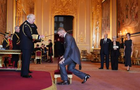 　チャールズ英国王（手前左）から爵位を授与されるデービッド・ベッカムさん＝４日、ロンドン近郊のウィンザー城（Ｊｏｎａｔｈａｎ　Ｂｒａｄｙ／ＰＡ通信・共同）