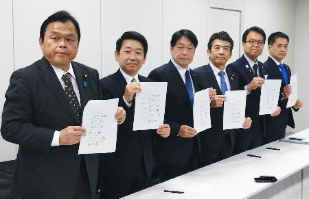 　協議を終え、合意文書を手に写真撮影に応じる与野党６党の税制実務者＝５日午前、国会