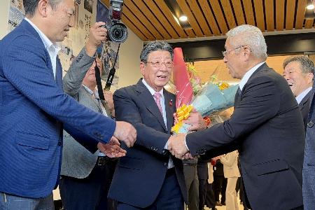 　退任式に集まった人たちと握手する宮城県南三陸町の佐藤仁町長（中央）＝５日午後、南三陸町